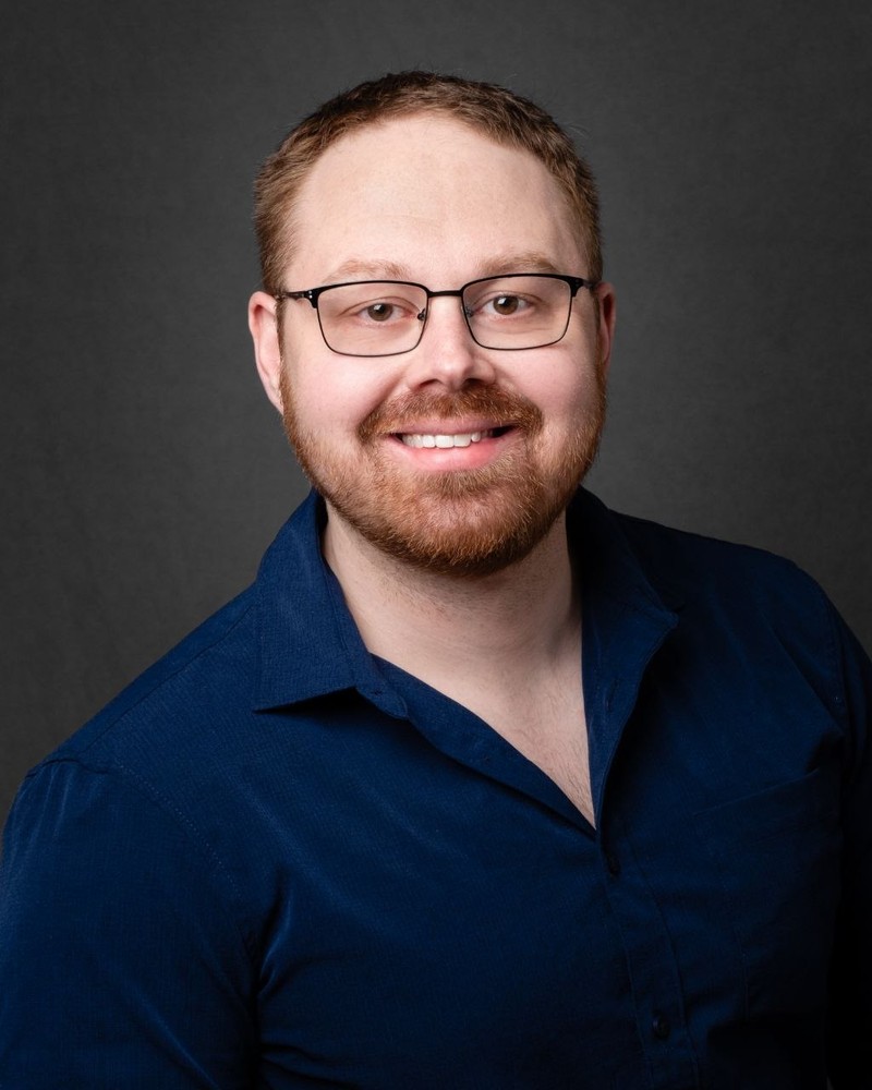Gary Dorman, smiling, wearing glasses and a navy shirt.